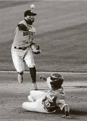  ?? Thearon W. Henderson / Getty Images ?? Second baseman Jose Altuve (27) throws over the top of Marcus Semien as he turns a double play for the Astros in the bottom of the third inning.