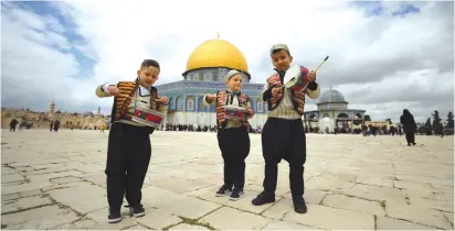  ?? (Ammar Awad/Reuters) ?? PALESTINIA­N CHILDREN, anticipati­ng the coming of Ramadan, perform in front of the Dome of the Rock last weekend.