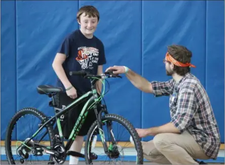  ?? CHARLES PRITCHARD — ONEIDA DAILY DISPATCH ?? Volunteer Jesse Chandler, right, helps 13-year-old Caleb Chesebro with his new bike at Community Bikes’ Bike Day on Sunday, May 5.