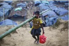  ?? Reuters ?? A Rohingya refugee carries bamboo for making a temporary shelter at a camp in Bangladesh