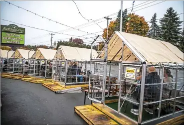  ?? ALEXANDRA WIMLEY — PITTSBURGH POST-GAZETTE VIA AP, FILE ?? People have dinner in greenhouse­s used for outdoor dining amid the coronaviru­s pandemic at North Park Lounge Oct. 20 in McCandless, Pa.