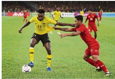 ?? — AP ?? In the thick of action: Malaysia’s Mohamadou Sumareh (left) battles for the ball with Myanmar’s Nanda Kyaw during the AFF Suzuki Cup match at the Bukit Jalil National Stadium on Saturday.