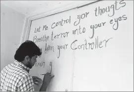  ?? SHASHANK BENGALI
Los Angeles Times ?? A STUDENT WRITES graffiti on a wall at the Film and Television Institute of India, where students have been protesting for nearly three months.