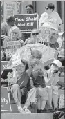  ?? Arkansas Democrat-Gazette/ STEPHEN B. THORNTON ?? A child gets shelter from the sun Friday at the state Capitol during the rally against the death penalty. Along with the speeches, a prayer was offered and hymns like “This Little Light of Mine” were sung.