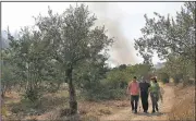  ?? AP/ARMANDO FRANCA ?? People flee a wildfire approachin­g a village Friday in central Portugal after winds and warmer weather Thursday rekindled blazes in the country. One fire in June killed 64 people.