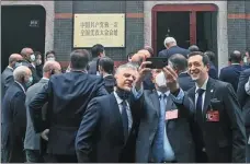  ?? CAO DESHENG / CHINA DAILY ?? Foreign diplomats take selfies while visiting the Site of the First National Congress of the CPC in Shanghai on Wednesday.