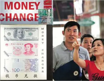  ?? Reuters ?? Heavy lifter People look at the exchange rate featuring the yuan and the dollar. The yuan will join the dollar, euro, pound and yen in the SDR allocation from October 1, 2016, at a 10.92 per cent weighting.