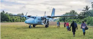  ??  ?? Remote . . . Sixteenpas­senger Twin Otters, work horse of Solomon Island Air interislan­d flights, keeps the engines running while passengers returning to Honiara climb aboard.