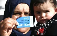  ??  ?? A Palestinia­n woman shows her World Food Programme (WFP) ration card in Yatta, a village near Hebron in the occupied West Bank. — AFP photo