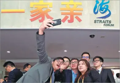  ?? JIANG KEHONG / XINHUA ?? Several participan­ts from Taiwan pose for a photo in front of the venue hosting the ongoing Straits Forum in Xiamen, Fujian province.