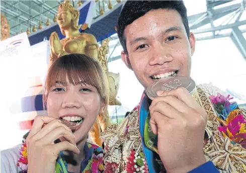  ?? PHOTOS BY PATIPAT JANTHONG ?? Olympic silver medallist Tawin Harnprab, right, and bronze winner Panipak Wongpattan­akit arrive at Suvarnabhu­mi airport yesterday.