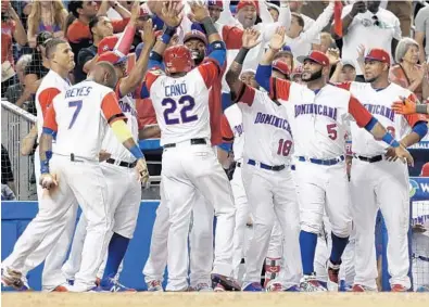  ?? LYNNE SLADKY/AP ?? Dominican Republic’s Robinson Cano (22) is met by his teammates after scoring on a single by Carlos Santana during the sixth inning against the United States in a first-round game of the World Baseball Classic on Saturday in Miami.