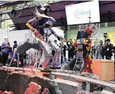  ?? AFP ?? Shape of things to come A robot HRP-2 (left), produced by Kawada, walks among mock debris during a demonstrat­ion at the annual Internatio­nal Robot Exhibition in Tokyo, Japan, yesterday.