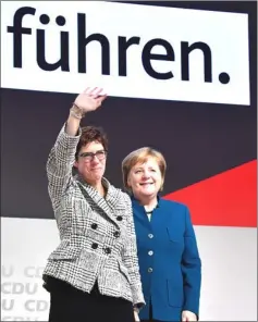  ??  ?? Annegret Kramp-Karrenbaue­r waves next to Merkel (right) during the CDU congress at a fair hall in Hamburg, northern Germany. — AFP photo