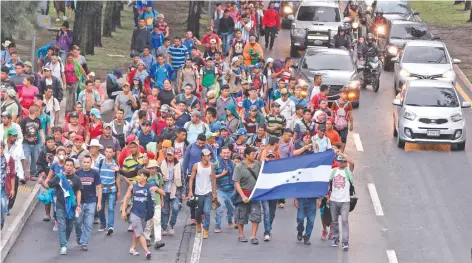  ??  ?? Migrantes hondureños caminan en dirección a Tecún Umán, tras dejar la capital guatemalte­ca. Su objetivo es cruzar a México y, después, ir a Estados Unidos.