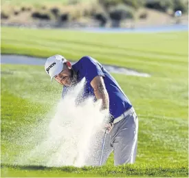  ??  ?? JB Holmes hits a bunker shot in the second round of the Phoenix Open.