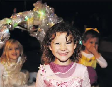  ?? Ryan Painter/The Signal ?? Teagan, middle, smiles before heading to the next house for candy and treats with her friends behind her on John Russell Drive in Valencia on Friday. See more Halloween activity on A3.