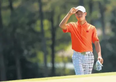  ?? MIKE EHRMANN/GETTY ?? Tianlang Guan walks up the 18th fairway during the second round of the Masters on April 12, 2013, at Augusta National Golf Club. Guan, a 14-year-old at the time, made the two-day cut at 4-over-par to become the youngest ever to complete the feat at the Masters.