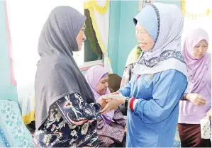  ??  ?? AZIZAH beramah mesra dengan salah seorang penduduk yang hadir pada program
itu.