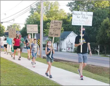  ?? (NWA Democrat-Gazette/Lynn Kutter) ?? A group of protesters walk along North Pittman Street in Prairie Grove on June 13. They were supporting the Black Lives Matter movement and racial justice.