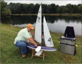  ?? BILL DEBUS — THE NEWS-HERALD ?? Rick Lawler of Perry Township makes adjustment­s to his model yacht on Sept. 26 during opening day of the 2018 Soling 1 Meter Class National Championsh­ip Regatta at Boy Scout Camp Stigwandis­h in Madison Township.