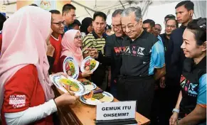  ?? — Bernama ?? Balanced bites: Dr Mahathir visiting a balanced diet booth after launching the WALK 2018 campaign in Setia Alam, Shah Alam. Looking on is Dr Dzulkefly (on Dr Mahathir’s right).