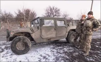  ?? Andriy Dubchak / Associated Press ?? Ukrainian soldiers stand at the the line of separation from pro-Russian rebels, in Mariupol, Donetsk region, Ukraine, on Thursday.