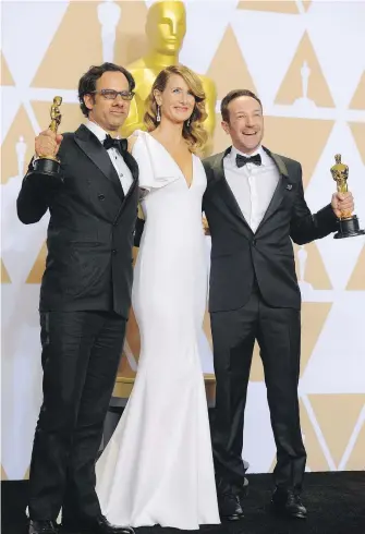  ??  ?? Winners of the “best documentar­y feature” Academy Award for their work on the movie Icarus, Dan Gogan, left, and Bryan Fogel flank Oscar presenter Laura Dern backstage Sunday at the 90th Academy Awards ceremony in Hollywood, California.