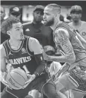  ?? DALE ZANINE/USA TODAY SPORTS ?? Hawks guard Trae Young, left, controls the ball, defended by the Hornets’ Cody Martin during the first half Wednesday at State Farm Arena in Atlanta.