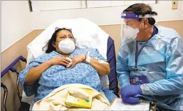  ?? Photograph­s by Francine Orr Los Angeles Times ?? COVID-19 PATIENT Maria Apolonia Mandujanu, 53, left, begins to cry as Dr. Brian Boyd asks her about lifesaving treatment preference­s in the emergency department at Providence St. Joseph Hospital in Orange.