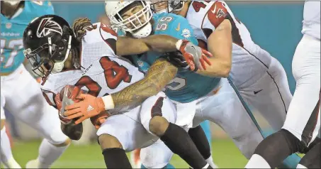  ?? Phelan M. Ebenhack / The Associated Press ?? Atlanta running back Devonta Freeman (left) tries to get away from Miami’s Koa Misi during the first half of Thursday’s preseason game.