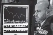  ?? DREW ANGERER Getty Images ?? A trader works at his desk at the closing bell on the floor of the New York Stock Exchange on Monday.