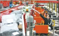  ?? ZHU XINGXIN / CHINA DAILY ?? Workers of SF Express sort packages at an outlet of the company in Beijing.