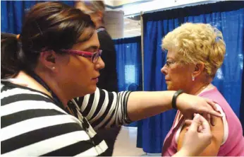  ?? CITIZEN FILE PHOTO ?? Registered nurse Melissa Ferreira gives Penny Stewart her flu shot at the Public Health flu clinic at the Healthier You Expo in October 2013.