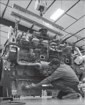  ?? REUTERS ?? A mechanic works on a CAT 3512 engine used to power hydraulic fracturing pumps at Holt Caterpilla­r, the largest Caterpilla­r dealer in the United States in San Antonio, Texas.