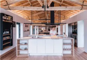  ?? MIGUEL DE GUZMAN PHOTOS IMAGEN SUBLIMINAL ?? Storage is built into the perimeter, as well as into fixed elements, of the renovated stable to create an open-room flow and highlight the wooden roof.