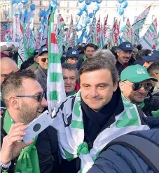  ??  ?? Sui social Carlo Calenda ieri alla manifestaz­ione dei sindacati a Roma in una foto postata dall’ex ministro accanto a quella di suo figlio con la bandiera del Pci