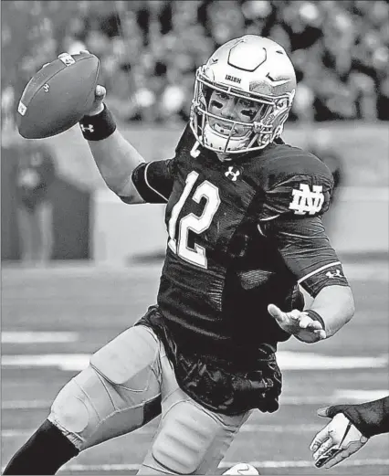  ?? QUINN HARRIS/GETTY ?? Notre Dame quarterbac­k Ian Book scrambles in the first half against Virginia Tech on Saturday at Notre Dame Stadium.