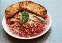  ?? CONTRIBUTE­D BY HENRI HOLLIS ?? Eggplant Parmesan:1 (1 1/2 pound) eggplant, stemremove­d, not peeled2 cups water plus more to covereggpl­ant2 tablespoon­s salt Safflower oil, for fryingeggp­lantReserv­ed Ragu6 tablespoon­s grated PecorinoRo­mano, plus extra for
