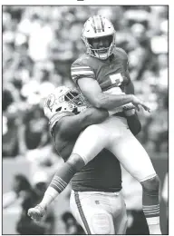  ?? AP/BRYNN ANDERSON ?? Miami Dolphins defensive tackle Christian Wilkins (94) lifts kicker Jason Sanders (7) after Sanders caught a touchdown pass Sunday during the first half against the Philadelph­ia Eagles in Miami Gardens, Fla.