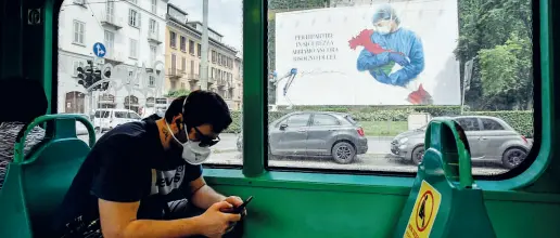  ?? (foto Furlan / LaPresse) ?? In tram Un passeggero Atm in via Broletto davanti al maxiposter dedicato dallo stilista Giorgio Armani a medici e infermieri italiani