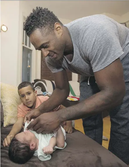  ?? DAVID BLOOM ?? Jesse Lipscombe changes newborn son Indiana Lipscombe’s outfit, while son Chile Lipscombe, 8, looks on at their home. Parents need to work on their relationsh­ip after baby arrives, writes Julia Lipscombe.