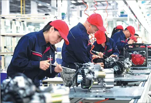  ?? BAO GANSHENG / FOR CHINA DAILY ?? Workers assemble digital electric generators at a production line of new energy cars in Ganzhou, Jiangxi province.