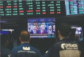  ?? (AP/Mark Lennihan) ?? Traders listen March 13 at the New York Stock Exchange to President Donald Trump’s televised speech from the White House in New York.