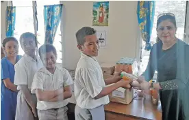  ?? Photo: Salote Qalubau ?? Circle of Friends member Naazrin Nisha distribute­s lunch packs to students of Saint Thomas Primary School in Lautoka on August 25, 2020.