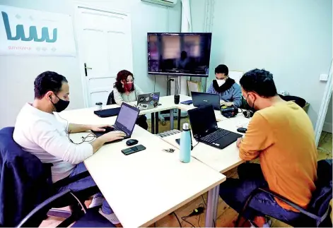  ?? — AFP photos ?? (From left) Syrian journalist Ayham al-Ghareeb, Spanish journalist Andrea Olea, Syrian journalist Okba Mohamed and Syrian journalist Muhammad Subat of Baynana bilingual media outlet work in their office in Madrid.