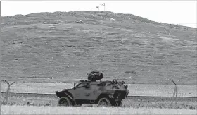  ?? AP/LEFTERIS PITRAKIS ?? A Turkish armored vehicle on Friday patrols the Syrian-Turkish border where Turkey has deployed forces and tanks but has declined to intervene in fighting between Syrian Kurds and the Islamic State group.