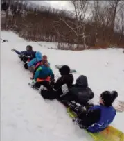  ?? JONATHAN TRESSLER — THE NEWS-HERALD ?? An 11-person sled train prepares to take the plunge down the hill at Riverview Park in Madison Township Dec. 14.