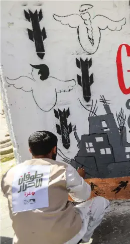  ?? ?? Displaced Palestinia­n artists paint a mural in Rafah to call