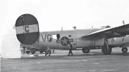  ?? ALBUQUERQU­E JOURNAL ?? A photo of what may have been the second parachute-assisted landing in history, with Garl McHenry standing near the tail and Fred Becchetti stooping under the plane.